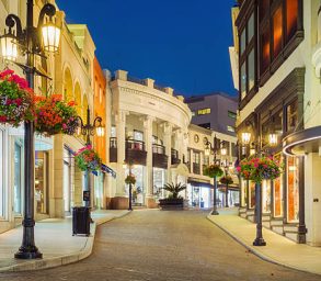 Photo of Rodeo Drive with illuminated stores in Beverly Hills, Los Angeles, California, USA at twilight blue hour.